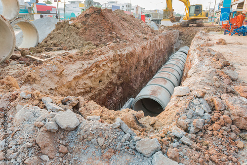 Concrete drainage tube row underground near construction site.Concrete pipe stacked sewage water system aligned on site. 