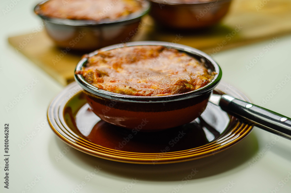 Traditional french onion gratin soup served in a ceramic bowl