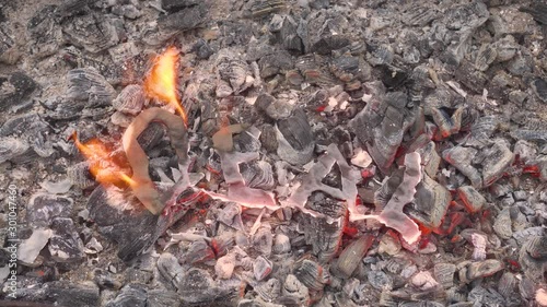 The abstract agreement burns in the fire on hot coals. A sign of loss or end. The destruction and disappearance of the word deal. Burning symbol and hope. The symbolic demise of the deal.