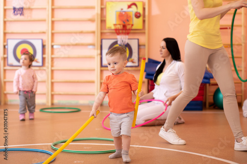 Fototapeta Naklejka Na Ścianę i Meble -  Kids with moms in gym. Healthy lifestyle and baby sport concept