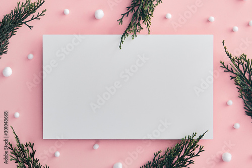 Christmas tree branch and snowball on pink background