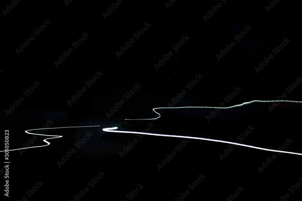 Motion blur car light trails on highway against black background Motion blur car light trails on highway against black background