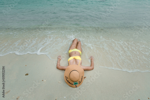 Top view Sexy woman in  swimming suit lie supine on paradise beach in Hawai island summer travel concept photo