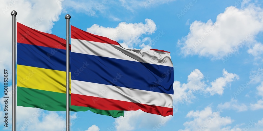 Mauritius and Thailand flag waving in the wind against white cloudy blue sky together. Diplomacy concept, international relations.