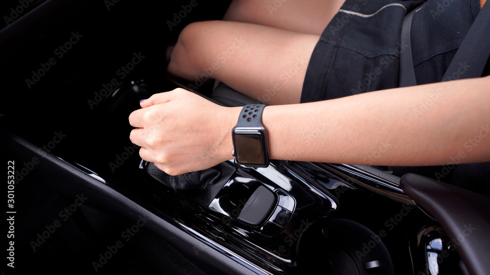 Hand of woman changing gear while driving car