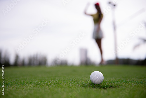 golf player putting golf ball into hole