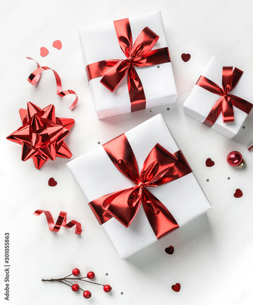 Merry Christmas card made of gift boxes, red decoration, sparkles and confetti on white background. Xmas and New Year holiday, bokeh, light. Flat lay, top view Merry Christmas card made of gift boxes, red decoration, sparkles and confetti on white background. Xmas and New Year holiday, bokeh, light. Flat lay, top view