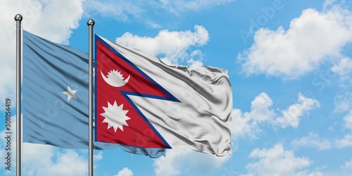 Micronesia and Nepal flag waving in the wind against white cloudy blue sky together. Diplomacy concept, international relations.