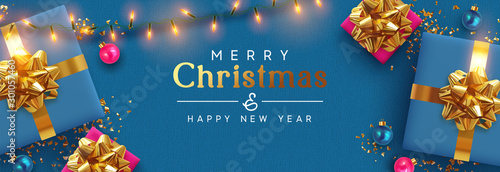 Holiday banner Merry Christmas and Happy New Year. Xmas design with realistic festive objects, blue gift box, lilac ball, light lamps garland, glitter gold confetti. Horizontal poster, flat top view