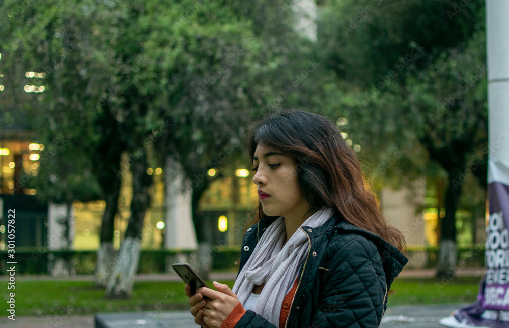 Fototapeta premium Portrait of woman texting in a cell phone