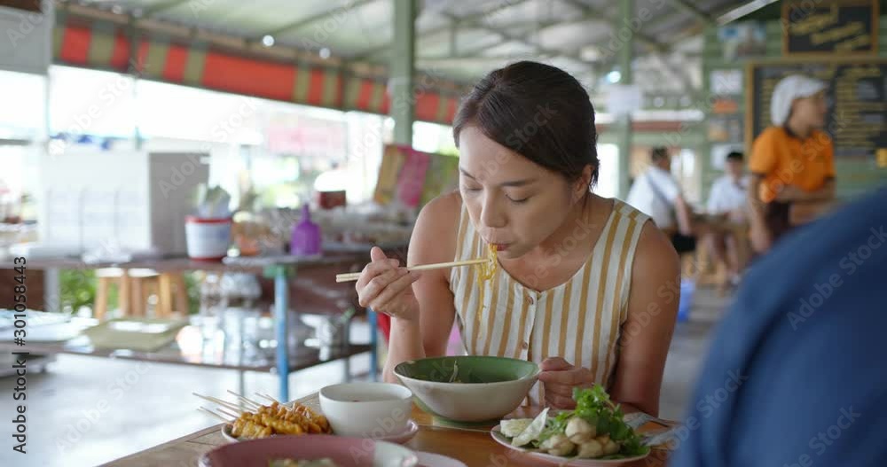 Woman eat with thai cuisine boat noodle at outdoor vendor store Woman eat with thai cuisine boat noodle at outdoor vendor store