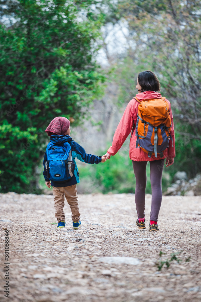 A woman with two children goes through the forest.
