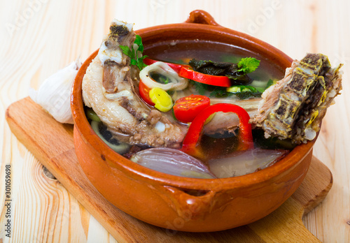 Soup of lamb with vegetables, lemon, onion and greens, served in bowl photo