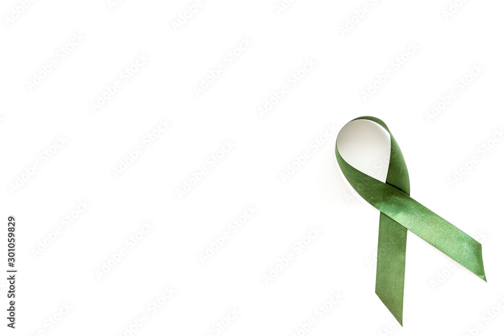 Green ribbon as symbol of disease control on white background top view copy space