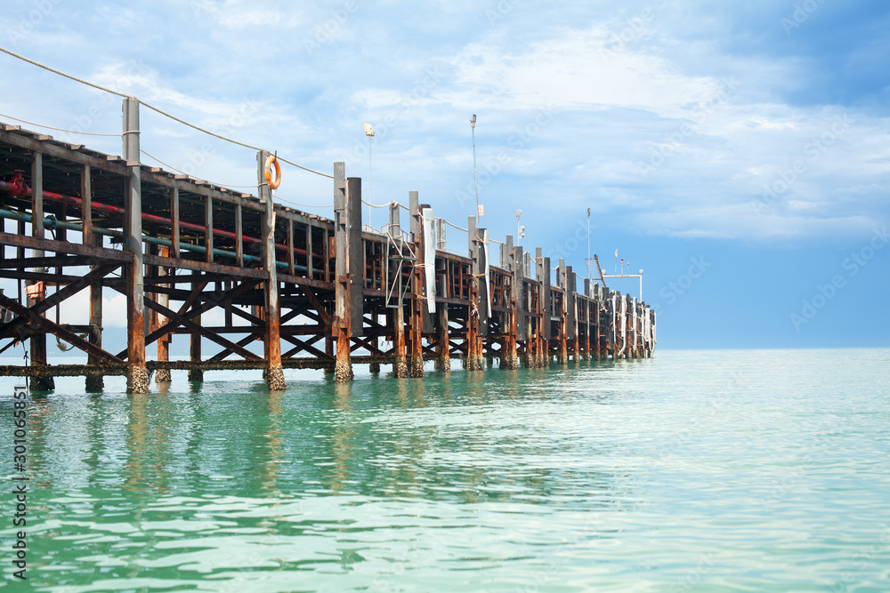 Obraz premium Wooden pier on turquoise water, blue sky, clouds background, ship wharf scenic perspective view seascape, fishing boat dock, beautiful old quay bridge, landing stage, jetty on Samui island, Thailand