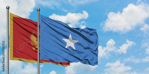 Montenegro and Somalia flag waving in the wind against white cloudy blue sky together. Diplomacy concept, international relations.