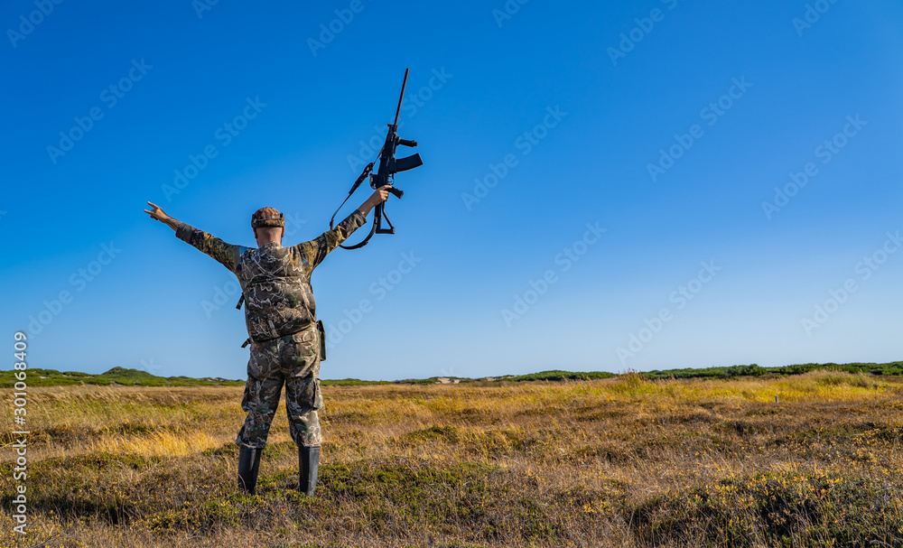 man with a gun standing in the field man with a gun standing in the field