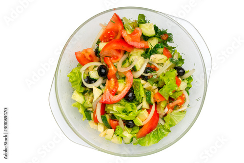 Vegetable salad in a glass dish, top view, close-up, isolated on a white background.