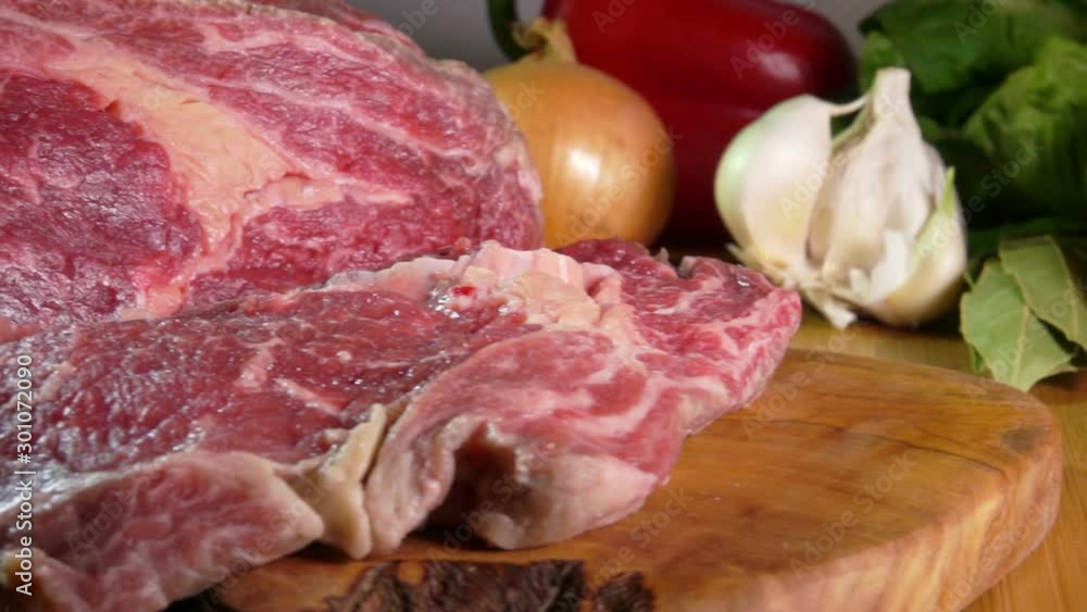 Close-up of raw meat cut with a knife into large appetizing steaks Close-up of raw meat cut with a knife into large appetizing steaks