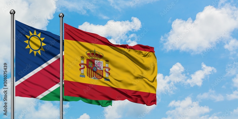 Namibia and Spain flag waving in the wind against white cloudy blue sky together. Diplomacy concept, international relations.