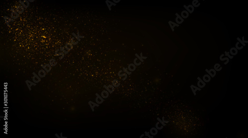 Glowing golden particles on black background 