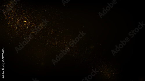 Glowing golden particles on black background	