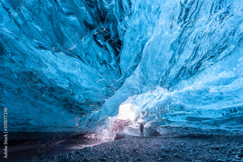 Canvas Print Tourist standing in an ice cave in Vatnajökull glacier Iceland