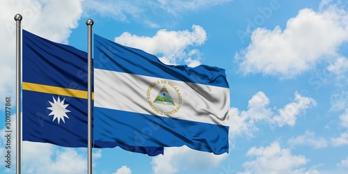 Nauru and Nicaragua flag waving in the wind against white cloudy blue sky together. Diplomacy concept, international relations.