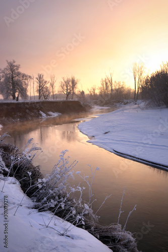 Winter morning on the river in the warm rays of the rising sun