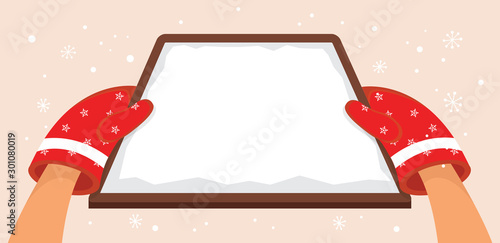 hands with winter red gloves holding Christmas bakery tray. card or invitation with place for your text.