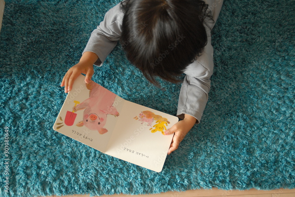 Fototapeta 絵本を読む子供 読み聞かせ 絵本 教育 幼児 コピースペース 余白 俯瞰 こども 子供 キッズ Naklejamy Com