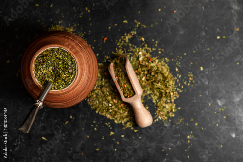 Beautiful composition of yerba mate on a black background - Juicy and green leaves without sticks