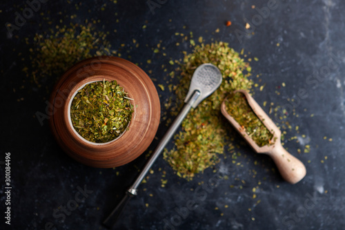 Beautiful composition of yerba mate on a black background - Juicy and green leaves without sticks photo