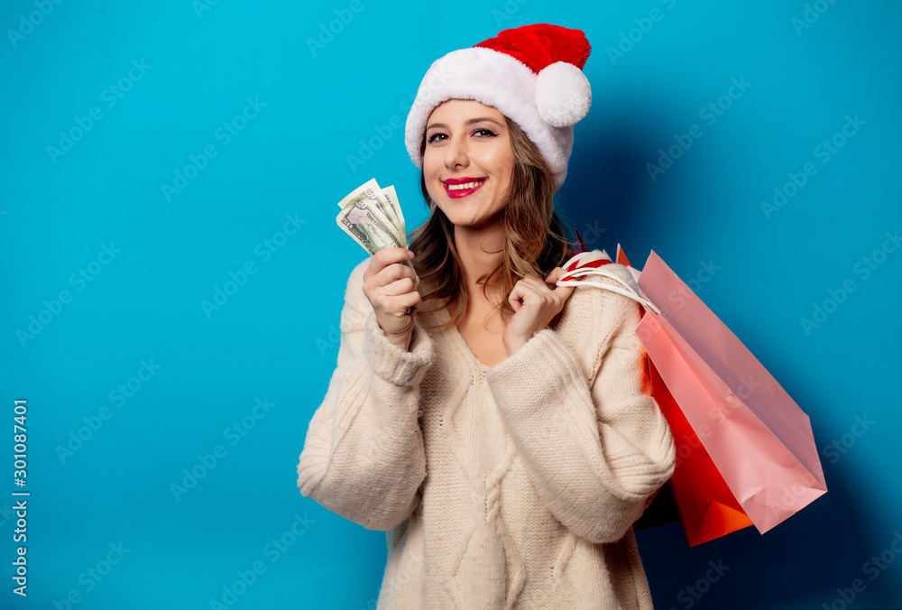 Beautiful woman with shopping bags and money clock on blue background Beautiful woman with shopping bags and money clock on blue background