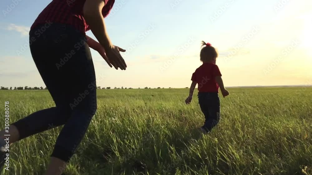 happy family catch up concept a mom and daughter play outdoors slow motion video. little girl runs across the field in the park, mom catches up with her playing catch-up. happy family outdoor happy family catch up concept a mom and daughter play outdoors slow motion video. little girl runs across the field in the park, mom catches up with her playing catch-up. happy family outdoor