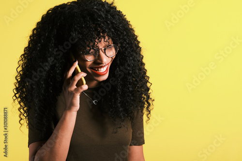 young curly haired afro american woman using her phone