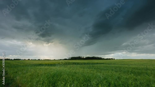 Rain storm above farmers field with light rays shining through 4K timelapse