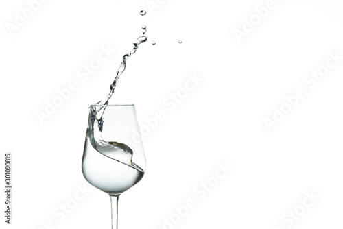 beautiful splashes of water in a wine glass, isolate on white, close up with copy space.