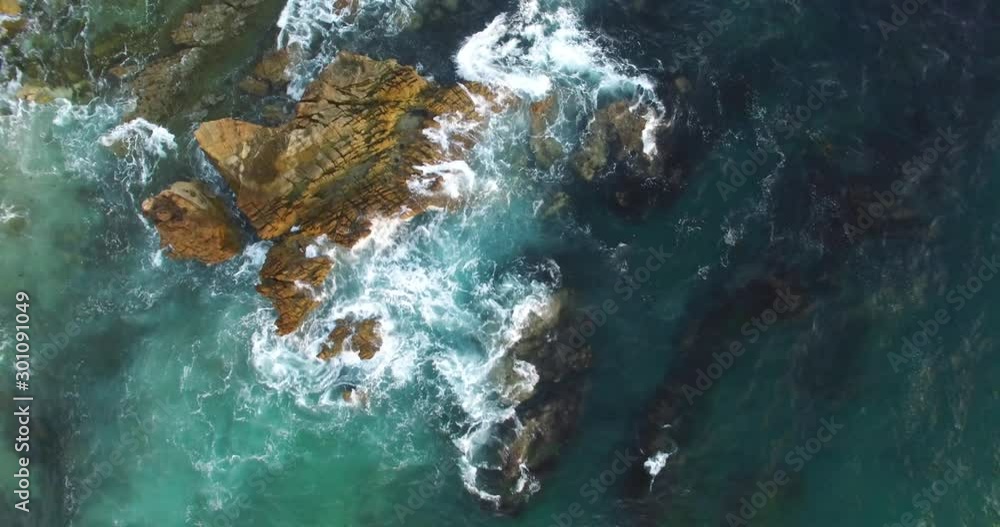 Top down 4K shot of waves breaking onto rocks in the ocean. Filmed in Laguna Beach, California. Top down 4K shot of waves breaking onto rocks in the ocean. Filmed in Laguna Beach, California.