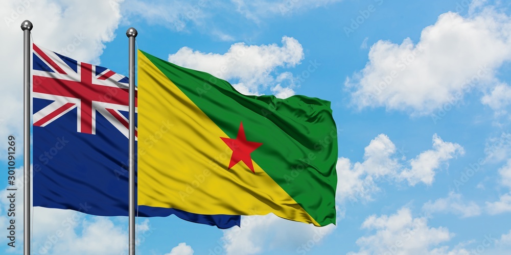 New Zealand and French Guiana flag waving in the wind against white cloudy blue sky together. Diplomacy concept, international relations. New Zealand and French Guiana flag waving in the wind against white cloudy blue sky together. Diplomacy concept, international relations.