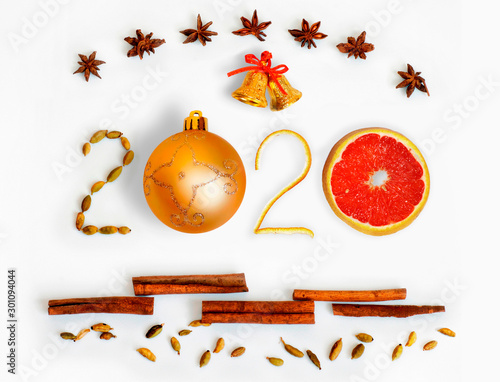 New Year 2020. 3D numbers with spices, grapefruit, bells and gold ball on a white background. Christmas card