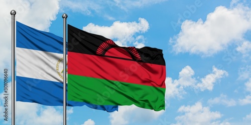 Nicaragua and Malawi flag waving in the wind against white cloudy blue sky together. Diplomacy concept, international relations.