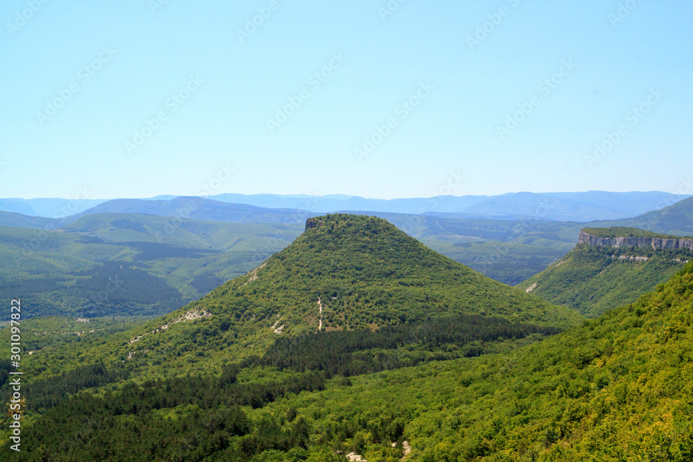Scenic views of mountain landscape, rocks and valley in the summer.  Beautiful minimalist landscape of green mountain ranges covered with forest.