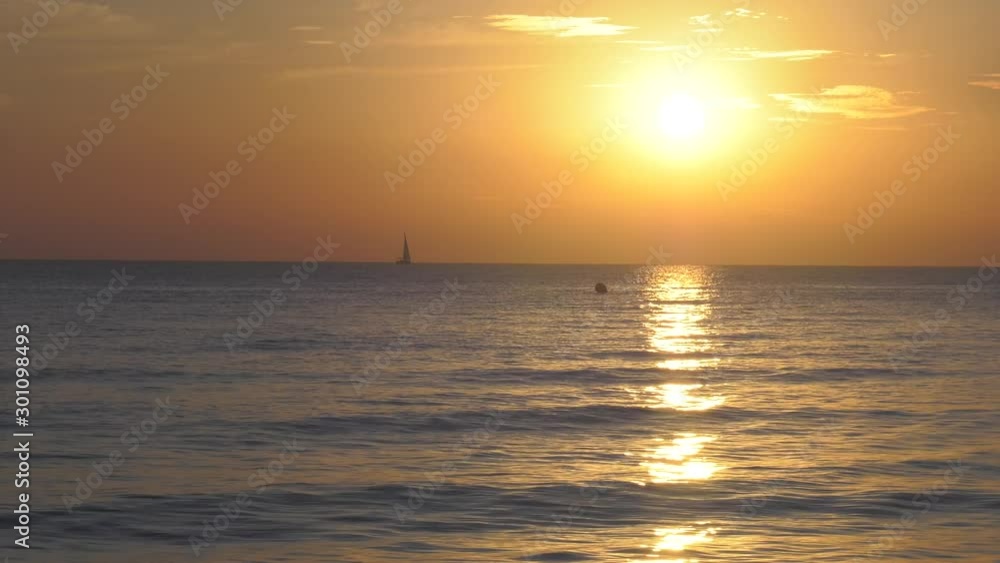 Sailing Yacht At Sunrise With Sunlight On Calm Sea Sailing Yacht At Sunrise With Sunlight On Calm Sea