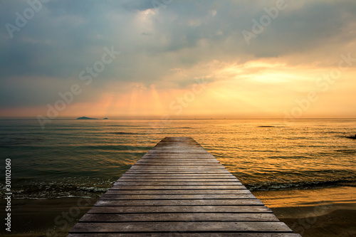 Fototapeta Naklejka Na Ścianę i Meble -  Golden sea sunset view of pier or jetty in the tropical in the summer.