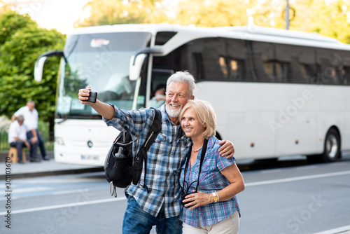 Cheerful senior tourists taking selfie