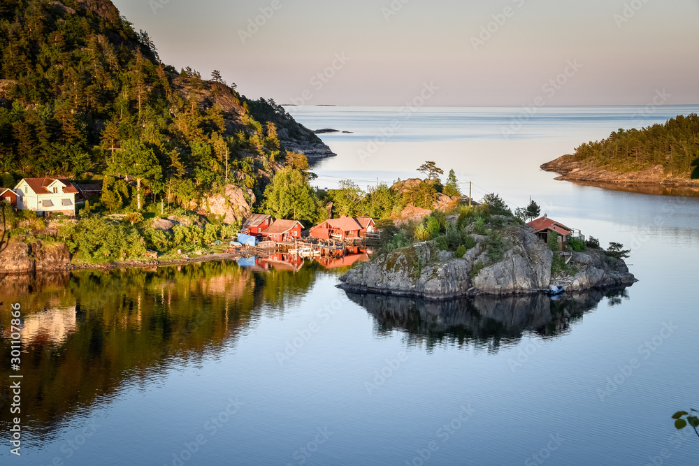 Fototapeta premium sunlight is shining on the red coastal houses of the Norwegian coast