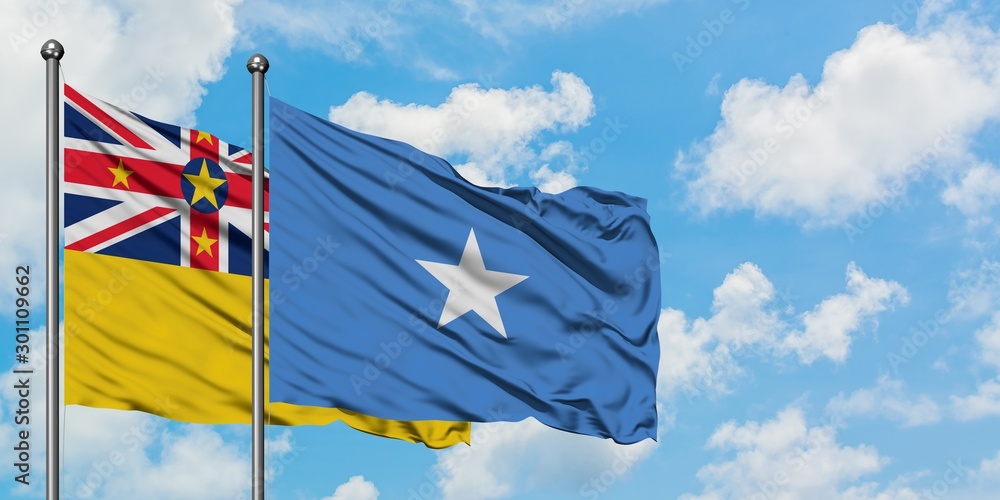 Niue and Somalia flag waving in the wind against white cloudy blue sky together. Diplomacy concept, international relations.