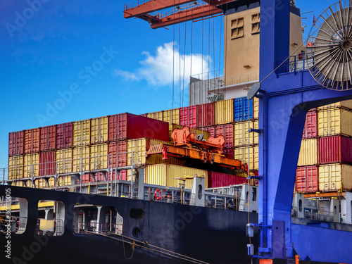 Industrial port crane lift up loading export containers box onboard from truck at port of Thailand,The port crane type's twinlift is the best solution for port operations. photo