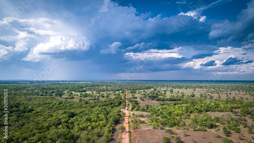 Aerial view of Transpantaneira dirt road with dramatic sky and rain crossing the typical landscape in North Pantanal Wetlands, Mato Grosso, Brazil photo